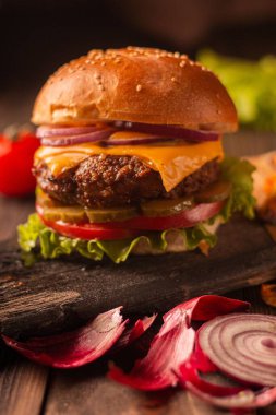 Sığır eti, peynir, soğan, domates ve turşulu yeşil salata ve patates kızartması.