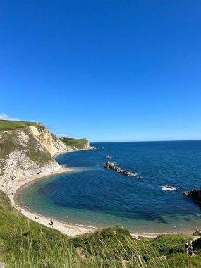 İngiltere 'nin Durdle Door kentindeki kayalıklardan deniz manzaralı sahilin dikey bir görüntüsü.
