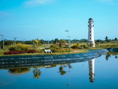 Güzel bir deniz feneri manzarası ve güneşli bir günde göldeki yansıması.