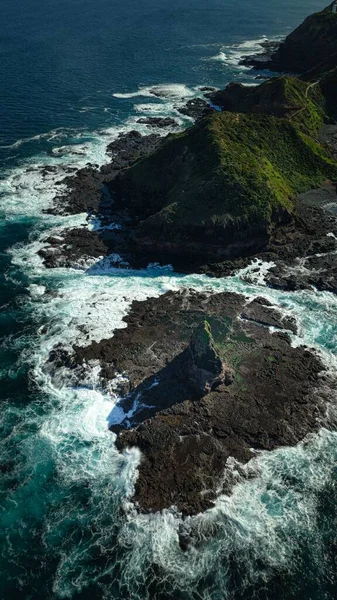 Eine Vertikale Luftaufnahme Von Meereswellen Die Die Felsformationen Krachen — Stockfoto