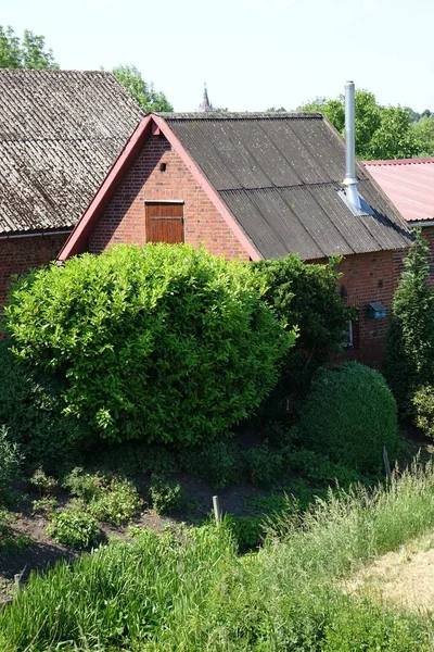 Een Verticaal Shot Van Een Baksteen Huis Met Groene Bosjes — Stockfoto