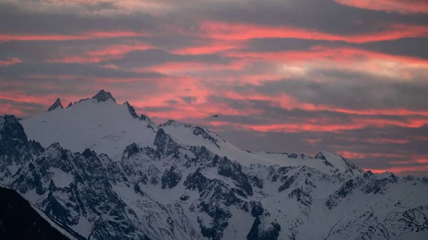 Karlı Dağların Üzerinde Açık Pembe Bir Günbatımı Gökyüzü — Stok fotoğraf