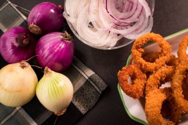 Masadaki soğan ve kızarmış soğan halkalarının üst görüntüsü.