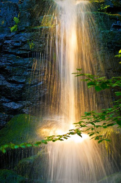 A vertical shot of a magical waterfall reflecting the sunlight in Germany