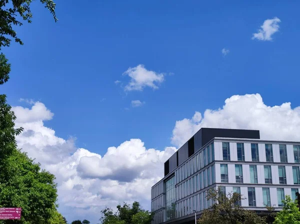 Modern Bir Bina Yeşil Ağaç Tepeli Bulutlu Bir Gökyüzü — Stok fotoğraf