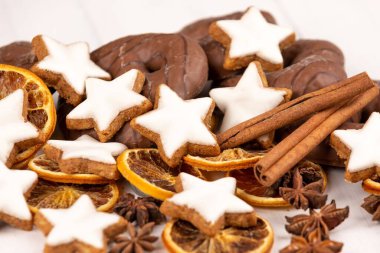 Tarçın yıldızı kurabiyeleri ve kurutulmuş portakalların yakın plan çekimi.