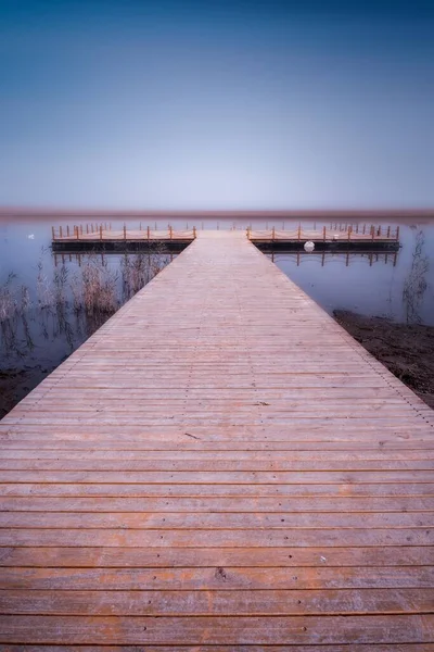 湖面上的一个木制甲板的垂直截图 地平线上有蓝天 — 图库照片
