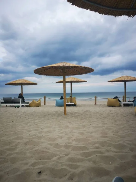 Люди Сидят Зонтиками Наслаждаясь Красивым Морским Пейзажем Облачный День — стоковое фото