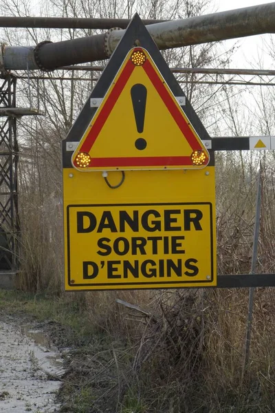 Yellow and red French traffic warning sign 'Danger! Exit of heavy vehicles' in industrial area, flashing warning lights, Seltz, Grand Est, France