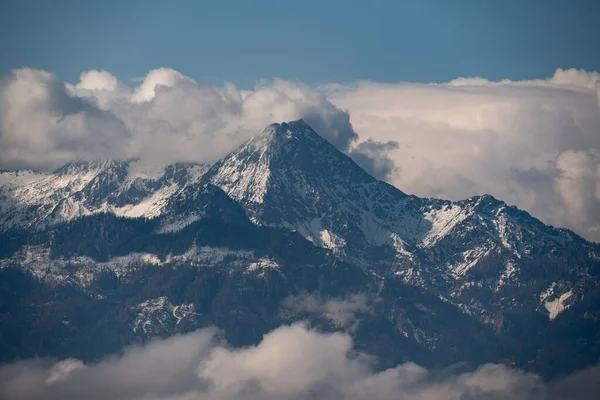 Μια Γραφική Θέα Χιονισμένα Βουνά Που Περιβάλλεται Από Αφράτα Σύννεφα — Φωτογραφία Αρχείου