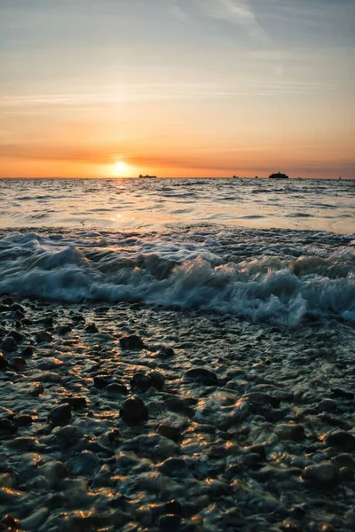 Eine Vertikale Aufnahme Ruhiger Meereswellen Während Eines Wunderschönen Sonnenuntergangs Auf — Stockfoto