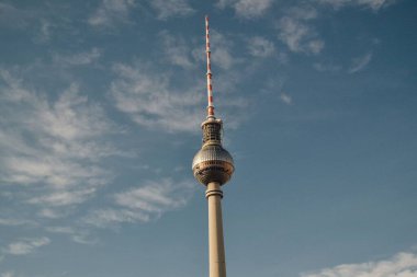 Berlin TV kulesinin alçak açılı görüntüsü bulutlu bir gökyüzünün altında