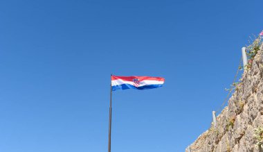 Hırvatistan 'ın Klisnear kenti yakınlarındaki bir direkte Hırvat bayrağının alçak açılı görüntüsü