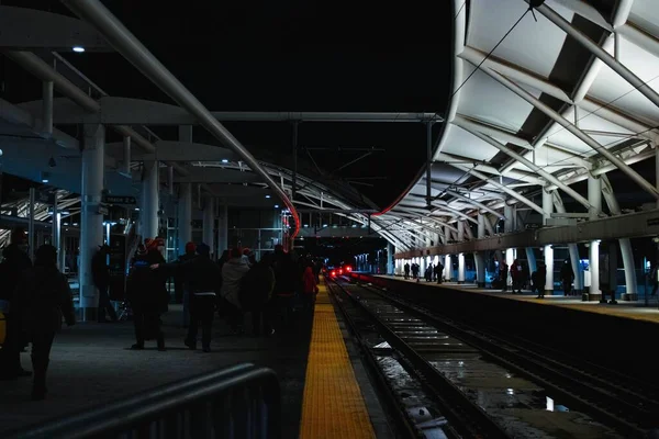 晚上和人在一个潮湿的火车站里 — 图库照片
