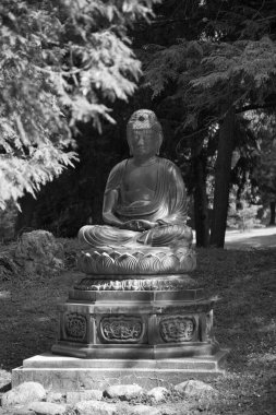 Park 'ta oturan Buda heykelinin dikey görüntüsü.