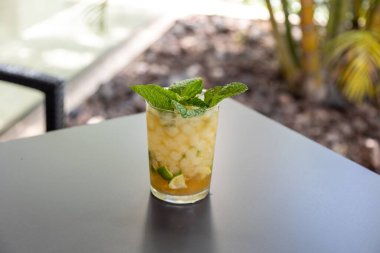 Masanın üstünde taze nane şekeri olan bir bardak nane likörünün yakın çekimi.