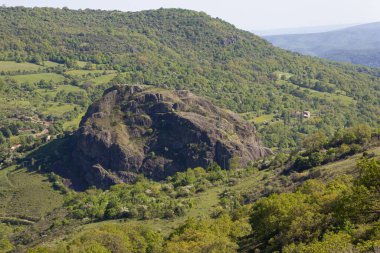 Fransa 'nın Sceautres şehrinde büyük bir kaya oluşumuna sahip güzel bir orman manzarası.