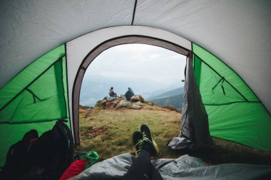 Dağlardaki bir kampta çadırdaki insanlar.