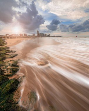 Hollanda, Vlissingen 'de arka planda ufuk çizgisi olan uzun pozlu bir okyanusun dikey çekimi.