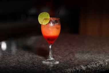 Bir bardak Sex on the Beach kokteyli saman ve limon dilimi mermer masada