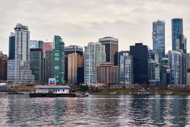 Yüzen benzin istasyonu Chevron Legacy yakıt mavnası kömür limanı Vancouver 'da, arka planda şehrin ufuk çizgisi manzarası.