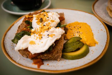 Avokado ve Benedict yumurtalarının yakın plan çekimi.