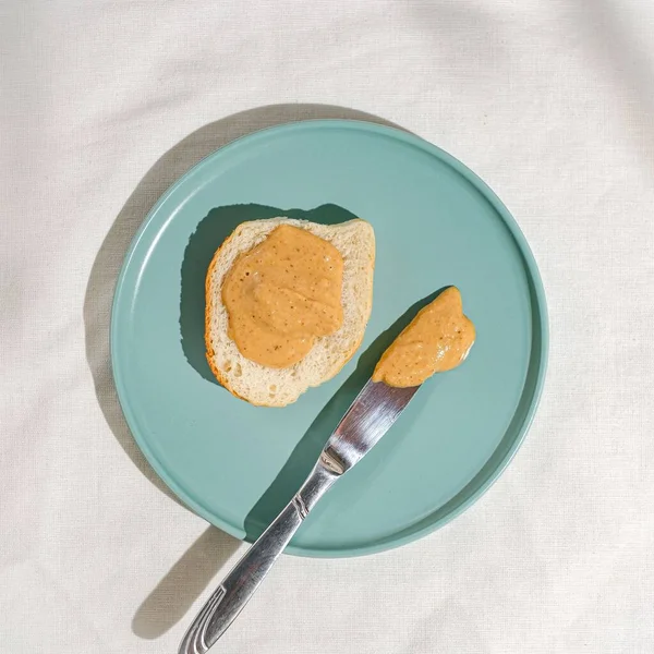 Mavi Tabakta Fıstık Ezmesiyle Kaplı Ekmek Bıçağın Üst Görüntüsü — Stok fotoğraf