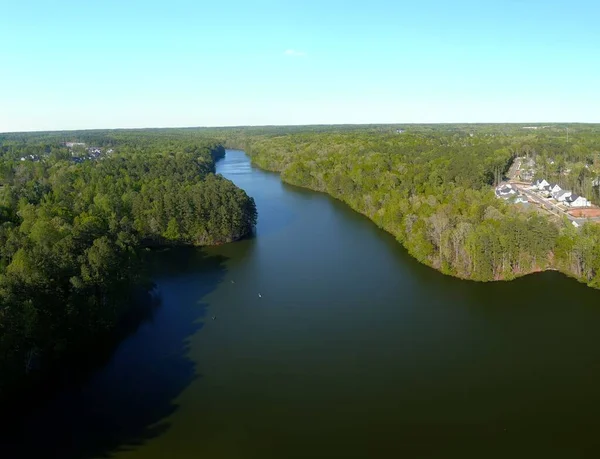青い空の下 鬱蒼とした森に囲まれた広い川のドローンビュー — ストック写真
