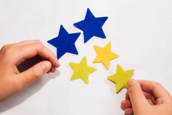 A shot of stickers in a star shape in the colors of the blue-yellow Ukrainian flag.