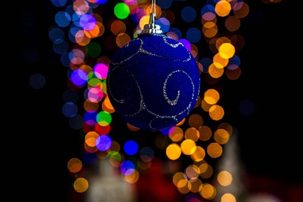 Bokeh Noel Işıklarıyla Süslenmiş Mavi Bir Noel Topunun Dikey Görüntüsü — Stok fotoğraf