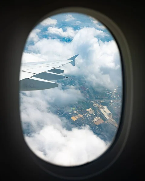 Вертикальный Снимок Крыла Самолета Окна Среди Облаков — стоковое фото