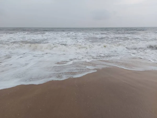 在灰蒙蒙的天空下 Calangute海滩上的泡沫和海浪 — 图库照片