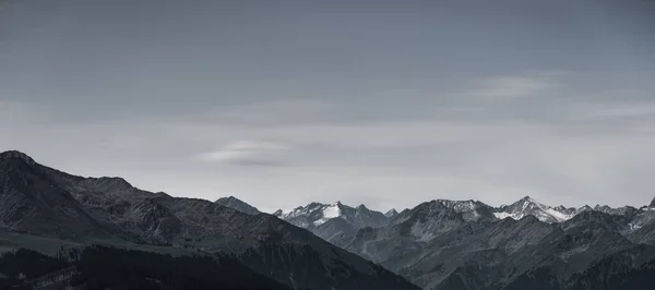 Een Panoramisch Shot Van Besneeuwde Bergtoppen — Stockfoto