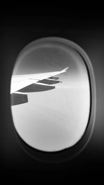 Tiro Vertical Uma Asa Avião Janela Escala Cinza — Fotografia de Stock