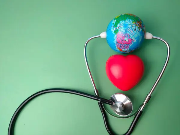 听诊器绿色背景上的听诊器 地球仪和红心 — 图库照片