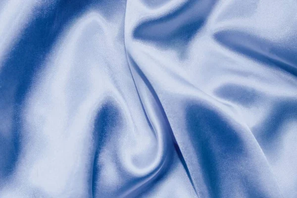 A shot of the shiny Maya blue silk satin background in waves