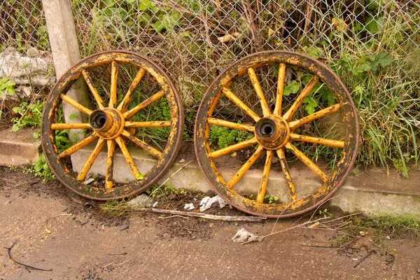 Zwei Alte Hölzerne Wagenräder Lehnen Einem Drahtzaun — Stockfoto