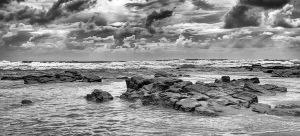 海的岩石海岸上一片灰蒙蒙的风景 布满了雷鸣般的云彩 — 图库照片
