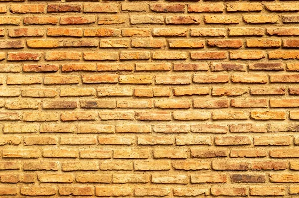 Yıpranmış duvarın pürüzsüz dokusu bej dekoratif tuğlayı tamamlıyor. Taş Duvar Deseni.