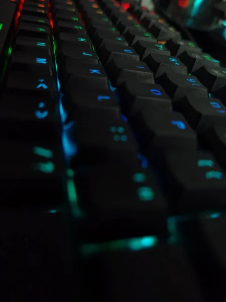 虹の照明キーと黒のコンピュータキーボードの垂直クローズアップショット — ストック写真