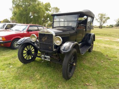 Old black Ford Model T Fordor Phaeton 1926 in the countryside. Nature green grass and trees. Classic car show. Copyspace clipart