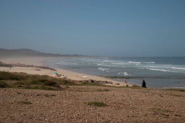 Kumsaldaki insanların manzarası ve güneşli bir günde güzel bir deniz.