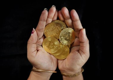 Elinde bitcoin tutan bir dişi.