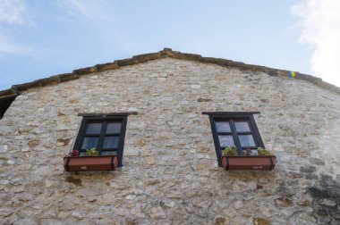 Bosna-Hersek 'te Osmanlı İmparatorluğu' ndan bu yana görülen geleneksel mimarinin düşük açılı çekimi. Mavi gökyüzünün altında eski bir taş ev