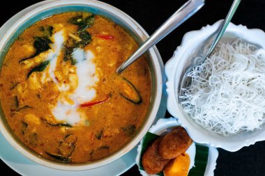 Yanında erişte olan baharatlı Tom Yum çorbası.