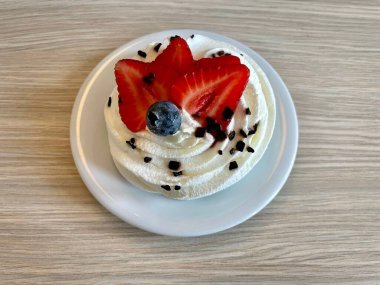 Krem şantili ve çikolatalı, çilek dilimli ve yaban mersinli Pavlova tatlısı. Pastaya Rus balerinin adı verilmiş.