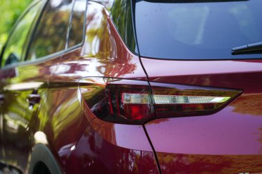 Kırmızı bir arabanın arka farının yakın plan çekimi.