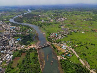Yeşil bitkilerle çevrili bir nehrin kuş bakışı manzarası.