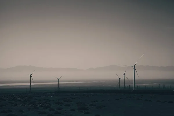 曇った暗い空の下の風力タービン — ストック写真