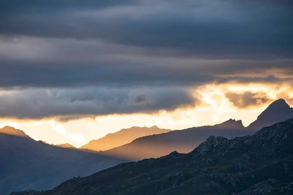 Eine Bergige Landschaft Der Die Sonne Unter Den Dichten Wolken — Stockfoto